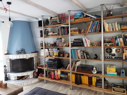a room with shelves filled with books and a tv at You can almost smell the sea! in Athens