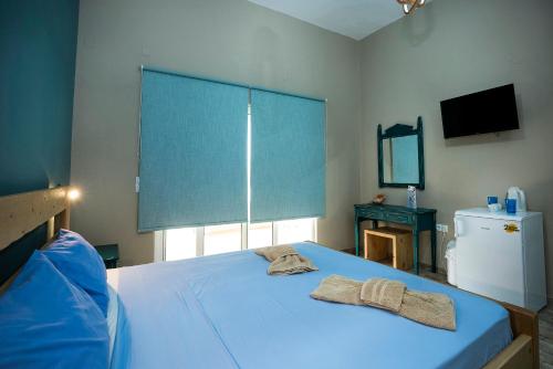 een slaapkamer met een blauw bed met 2 handdoeken erop bij Naya in Kissamos