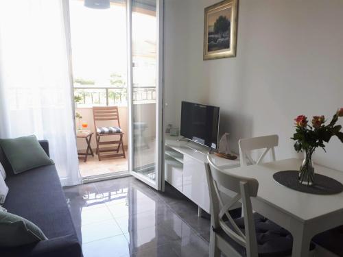 a living room with a table and a tv at Apartment ENI with garage parking in Split