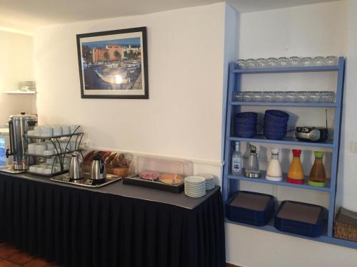 a kitchen with a black counter with dishes on a shelf at Hotel Bellevue in Saint-Florent