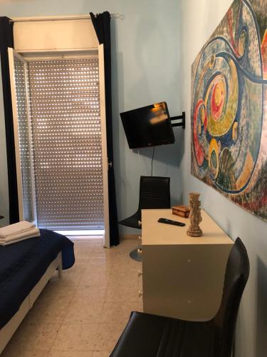 Habitación con escritorio y una pintura en la pared. en Casa Cristina, en Maiori