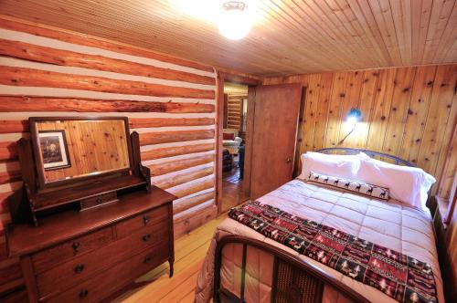 a bedroom with a bed and a wooden wall at Glacier Homestead in Coram