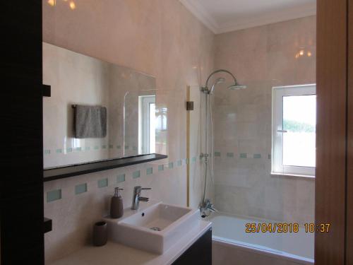 Casa Rosa في لاغوس: حمام مع حوض ومرآة وحوض استحمام