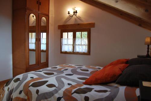 1 dormitorio con 1 cama y 2 ventanas en Casa Rural Natura Sobron en Sobrón