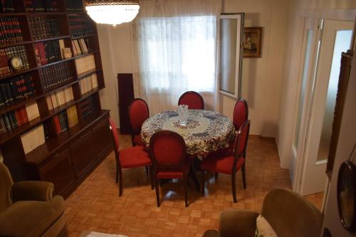 a dining room with a table and red chairs at George appartment in Athens