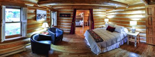 a bedroom in a log cabin with a bed and a chair at Glacier Homestead in Coram
