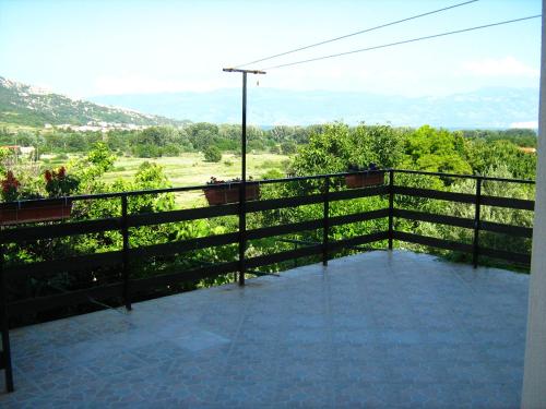 a balcony with a fence and a view of a field at Podmartine in Baška