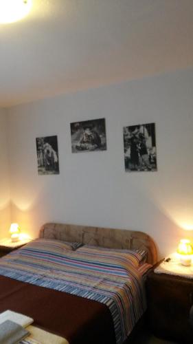 a bedroom with a bed with pictures on the wall at Podmartine in Baška