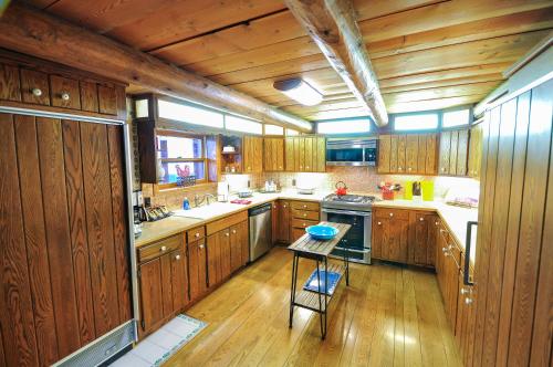 a kitchen with wooden cabinets and a small table in it at Glacier Homestead in Coram