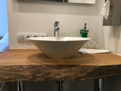 a white bowl sink on a wooden counter at Gasthof zum Waldstein in Zell im Fichtelgebirge