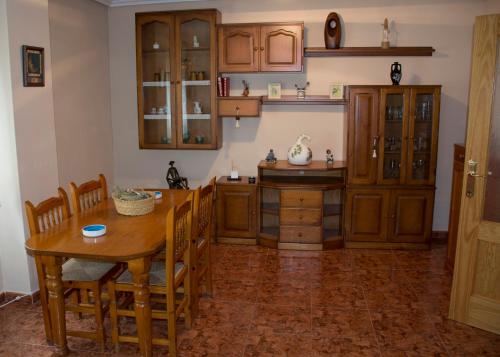 cocina con mesa de madera y armarios de madera en Apartamentos Ruidera en Ruidera