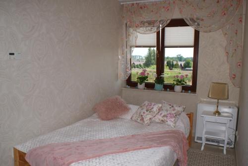Habitación pequeña con cama y ventana en Różany Zakątek en Sarbinowo