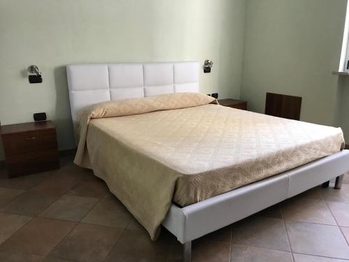 una camera da letto con un letto bianco in una stanza di Appartamenti Corallo ad Alba Adriatica