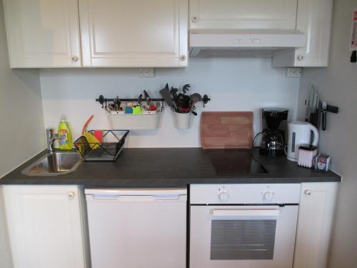a kitchen with white cabinets and a black counter top at Lækjaborgir Guesthouse in Kálfafell