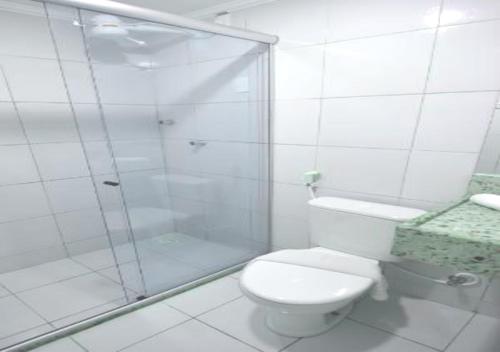 y baño blanco con ducha y aseo. en Pousada Boi Bumba Tambau, en João Pessoa