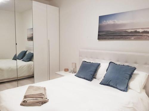 1 dormitorio con cama blanca y almohadas azules en Fabulous view on the Lake, en Valsolda