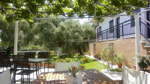 a patio with a table and chairs in a yard at Gorgona Rooms in Alyki