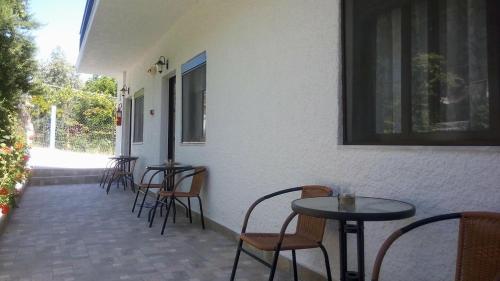 a row of tables and chairs next to a building at Gorgona Rooms in Alyki