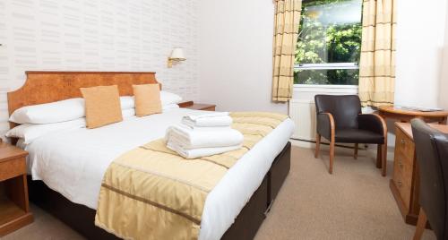 a bedroom with a bed with a desk and a chair at Pitbauchlie House Hotel - Sure Hotel Collection by Best Western in Dunfermline