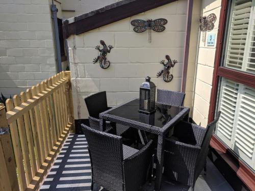 a black table and chairs on a patio at Creek View in Wootton Bridge