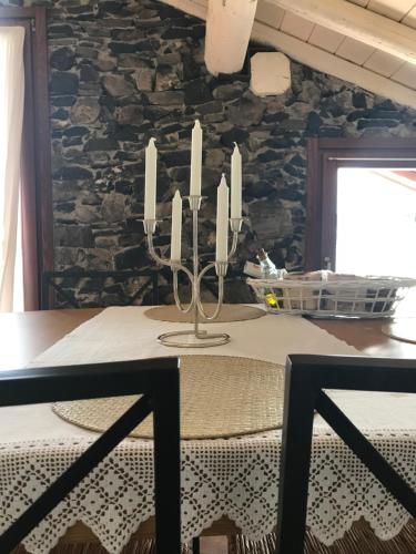 a dining room with a table and a stone wall at Apartment The Rock in Brienno