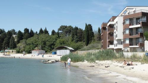 un grupo de personas en una playa cerca de un edificio en Akrotiria Beach Apart Complex, en Nesebar