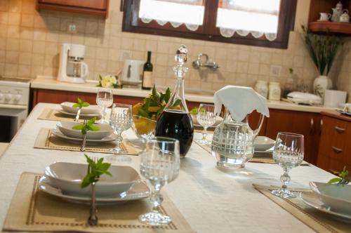 una mesa de cocina con platos y copas de vino. en Casa Elaia, en Áyios Dhimítrios
