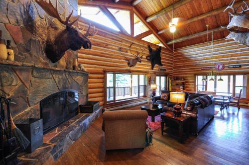 a living room with a large fireplace in a log cabin at Glacier Homestead in Coram
