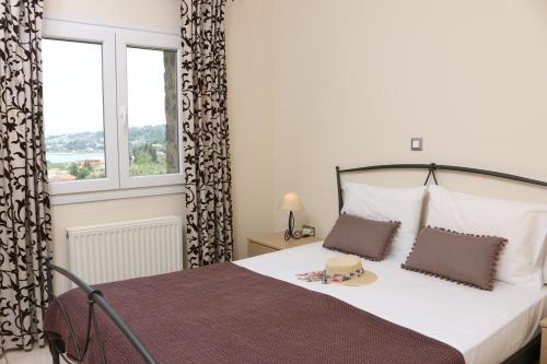 1 dormitorio con 1 cama con 2 almohadas y ventana en Corfu View Deluxe, en Perama