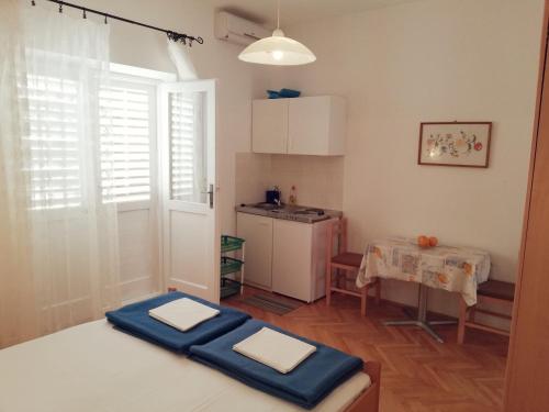 Habitación con cocina con mesa y alfombra azul. en Apartments Marika, en Drasnice