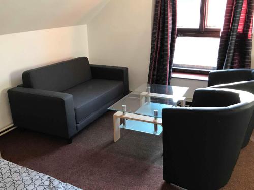 a living room with two chairs and a couch and a table at Penzion Měšťan in Jindrichuv Hradec