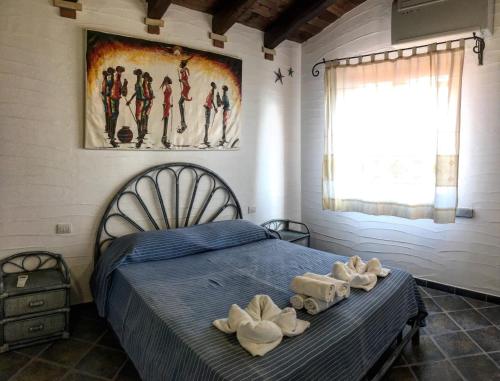1 dormitorio con 1 cama con toallas en Il Sogno Tanca Piras, en Nebida
