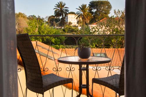 d'une table et de deux chaises sur un balcon. dans l'établissement Villa Fabulite, à Antibes