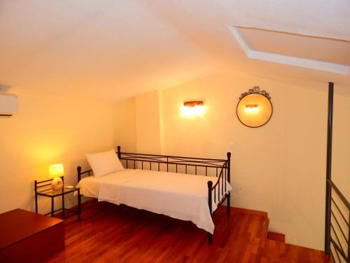 a bedroom with a bed and a clock on the wall at Kripis Studio Paliouri in Paliouri