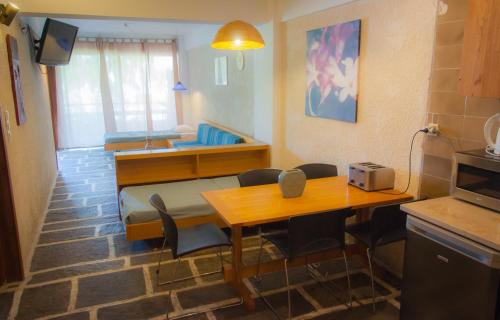 a living room with a table and a dining room at Apollonia Hotel Apartments in Varkiza