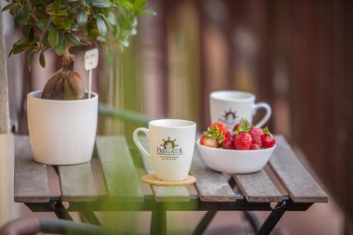 two cups and a bowl of strawberries on a table at Fregata in Ustka
