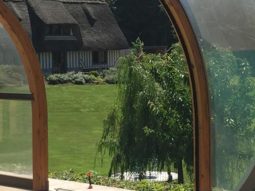 a window view of a house with a tree at Holiday home Le clos du phare in Saint-Samson-de-la-Roque