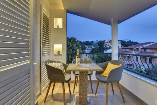 een tafel en stoelen op een balkon met uitzicht bij Apartments Zanetti 2 in Pula