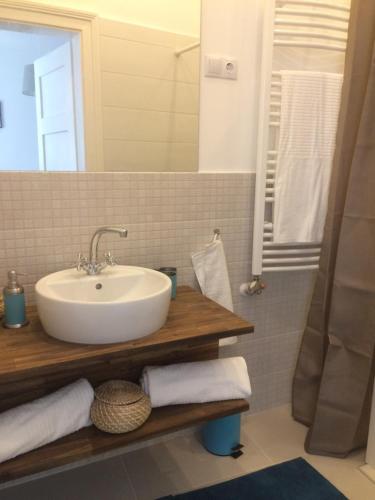 a bathroom with a sink and a mirror at Enjoy Apartman in Sopron