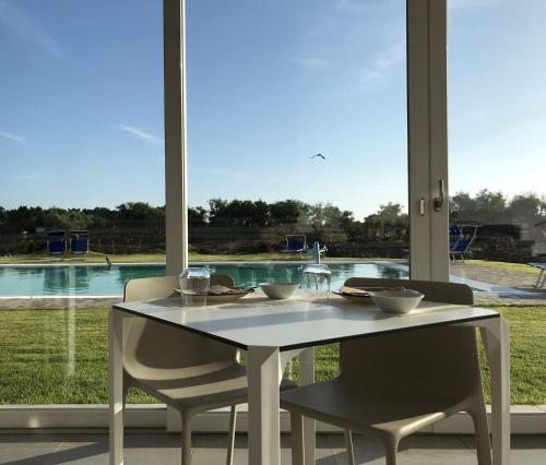a white table and chairs with a view of a pool at 309 Le Saline - Stintino in Stintino