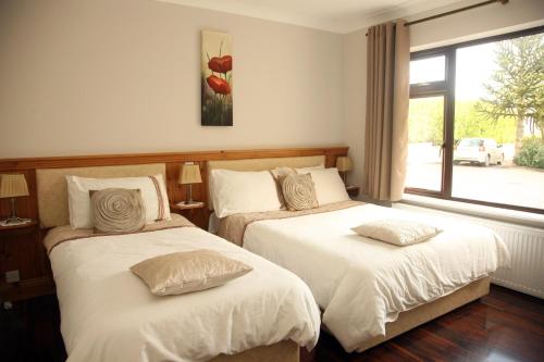 a bedroom with two beds and a window at Torine House B&B in Killorglin