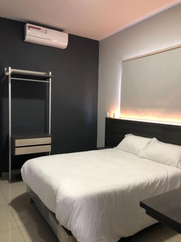 a bedroom with a large white bed and a window at Hotel Doral Inn in Ibagué