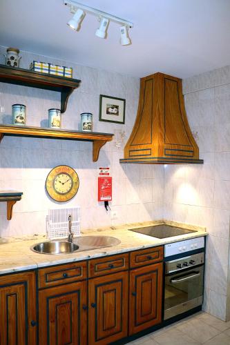 a kitchen with a sink and a stove top oven at Porto Patricio Apartments in Porto