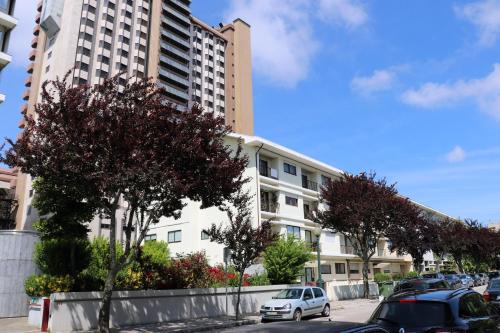 a parking lot with cars parked in front of a building at Porto Patricio Apartments in Porto