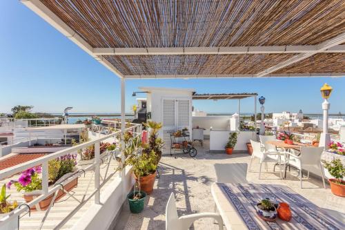 a balcony with a table and chairs and a view of the ocean at AL - Alojamento Local Pension Bicuar in Olhão