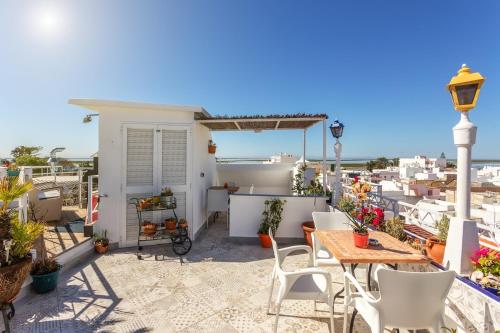 a balcony with tables and chairs and a view of the ocean at AL - Alojamento Local Pension Bicuar in Olhão