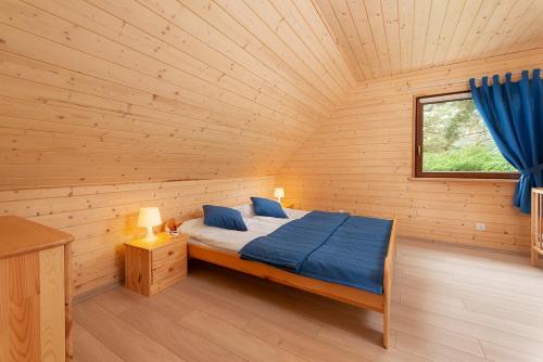 a bedroom with a bed in a wooden cabin at ALKADO Jastrzebia Gora in Jastrzębia Góra