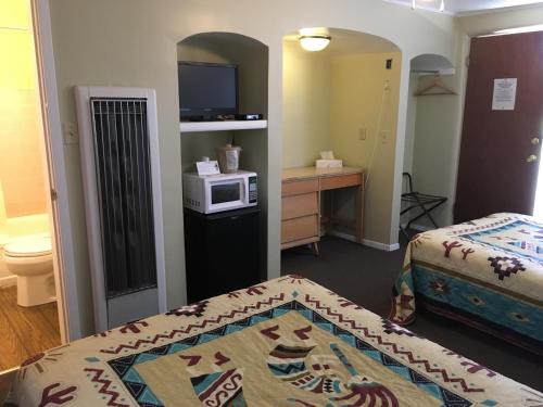 a room with two beds and a microwave at Sun -N- Sand Motel in Kanab