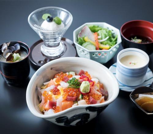 a bowl of food on a table with bowls of food at HOTEL MYSTAYS PREMIER Sapporo Park in Sapporo
