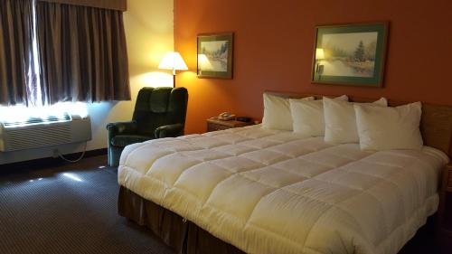 a hotel room with a large bed and a chair at Motel 6 Norway MI in Norway